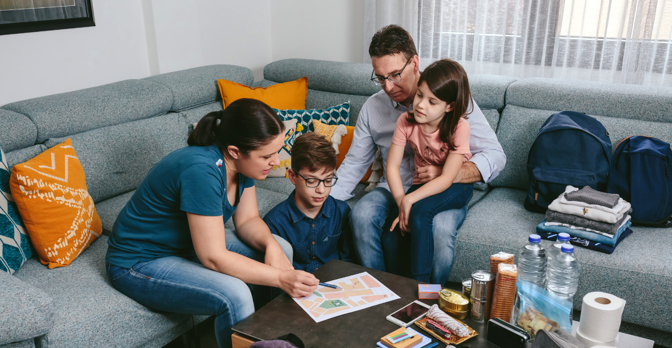 Parents and two children on couch reading an emergency plan.